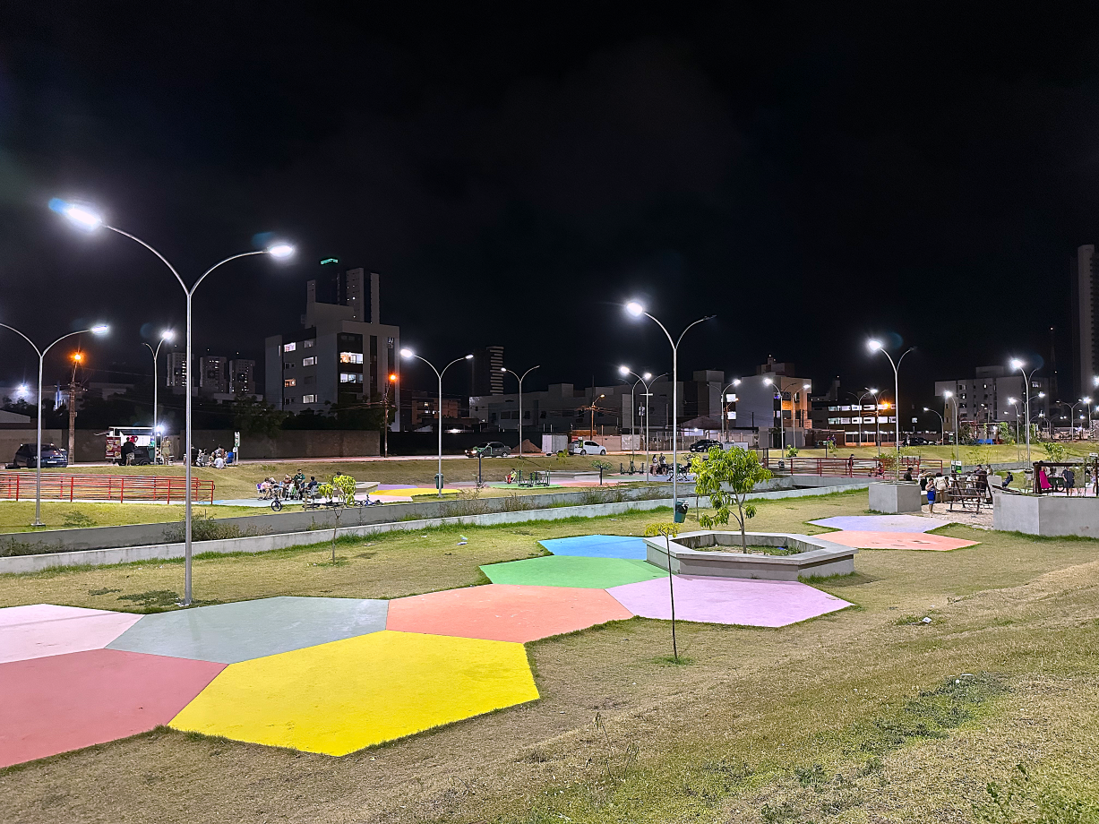 Foto à noite no Parque Parahyba IV monstrando calçada colorida e pessoas ao fundo